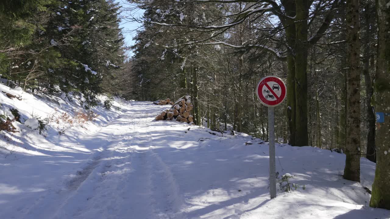 Snow covered rural road not suitable for motor vehicle in Vosges France countryside