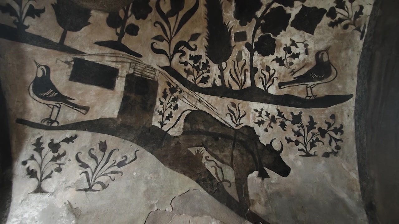 Antico affresco di bue e uccelli su parete in pietra