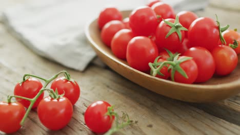 video of fresh cherry tomatoes in bowl over wooden background