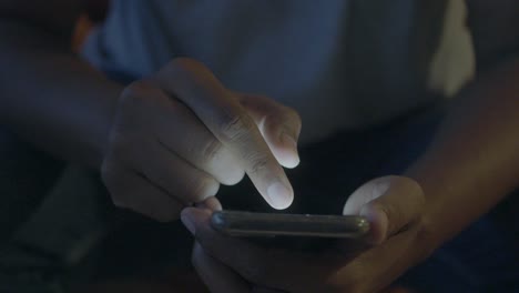 persona que utiliza un teléfono inteligente por la noche