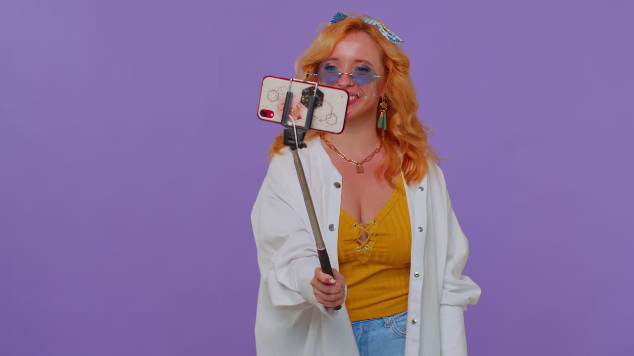 blogger viajera con gafas de sol, tomando selfies en el teléfono móvil, comunicándose por video llamada en línea