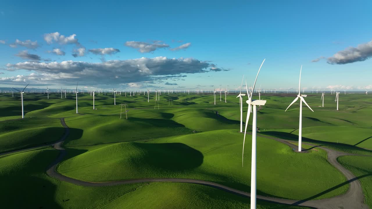 Wind Turbine Farm propellers spinning is slow motion, Green rolling hills blue sky, Montezuma Hills, California