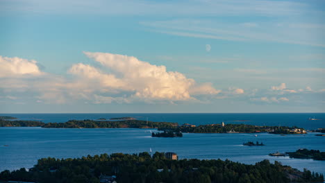 Timelapse-of-sunlit-clouds-and-moon-moving-over-the-Suomenlinna-island,-Helsinki