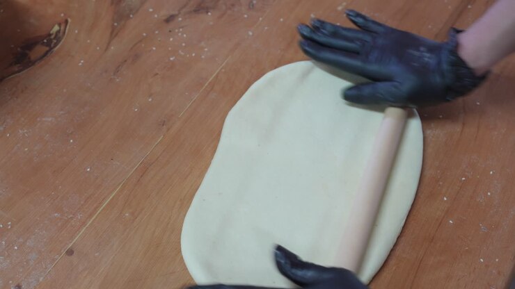 Close-up of rolling out the dough to make traditional Flaouna pastries