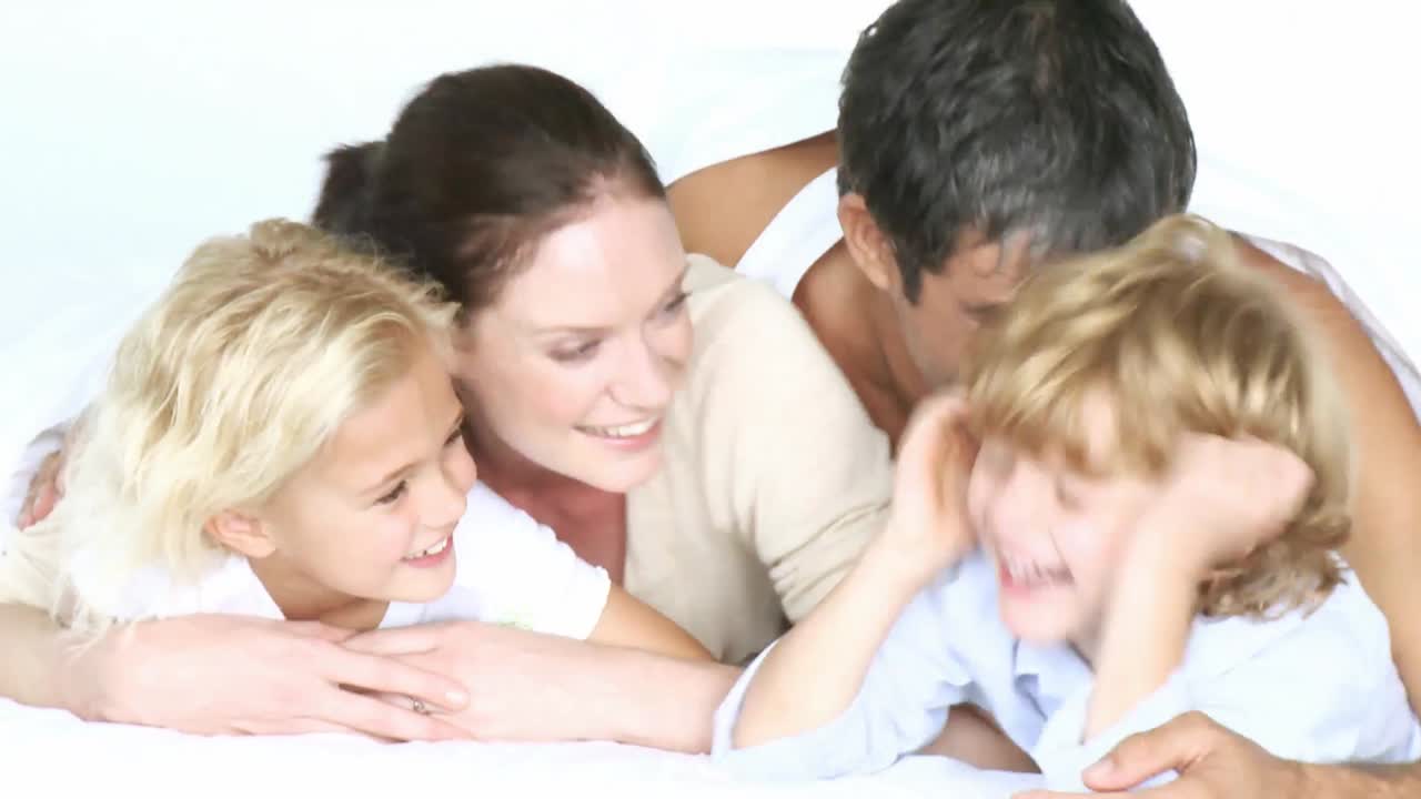 침대에 누워있는 행복한 가족