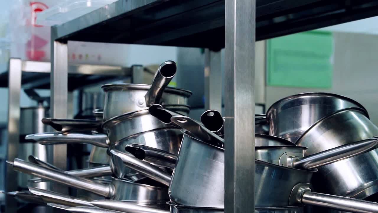 Cooking utensils in the kitchen. Stainless pans and pots. Clean cooking equipment composed under table in the restaurant