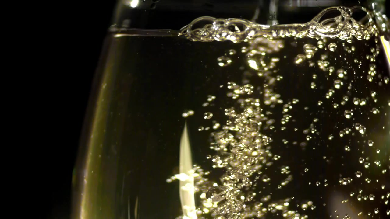 Bollicine di champagne dorate che salgono in un calice su uno sfondo scuro