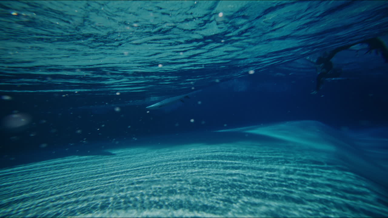 Underwater view of waves in an artificial wavepool, slow motion capture shows dynamic patterns and reflections