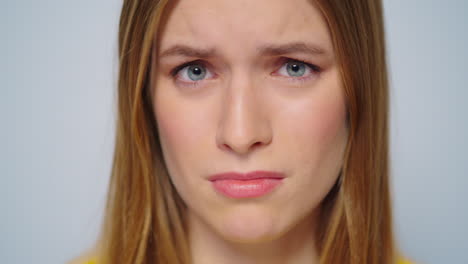 closeup worried woman looking at camera on grey background in studio.