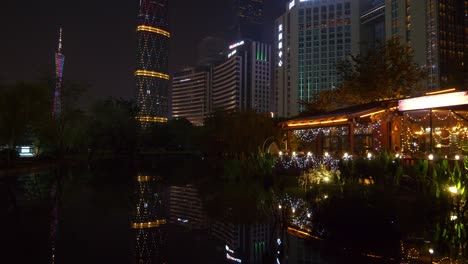 night illuminated guangzhou city downtown megatalls buildings pond reflection panorama 4k