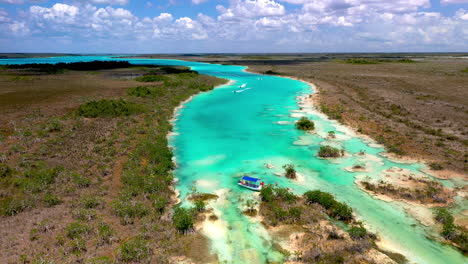 cinematic drone shot of clear blue waters and jet skiers at bacalar mexico