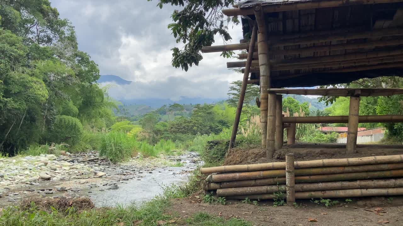 proceso de construcción de casas de bambú en las orillas de un río tropical en colombia