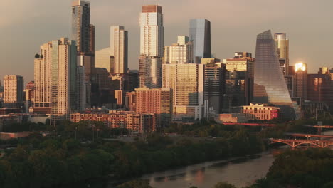 drone slowly rises from zilker park to reveal a close-up view of downtown austin. the shot highlights modern architecture, warm tones, and lush greenery in a cinematic aerial composition