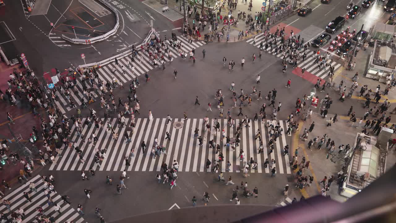 People crossing the road at nighttime in Tokyo at Shibuya Crossing