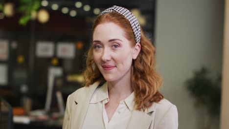 portrait of happy caucasian businesswoman looking at camera at office