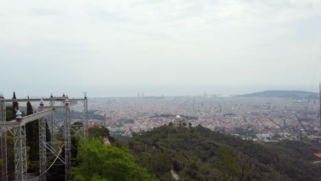 Stunning-video-of-a-girl-observing-the-city-of-Barcelona-below,-her-hair-dancing-in-the-wind