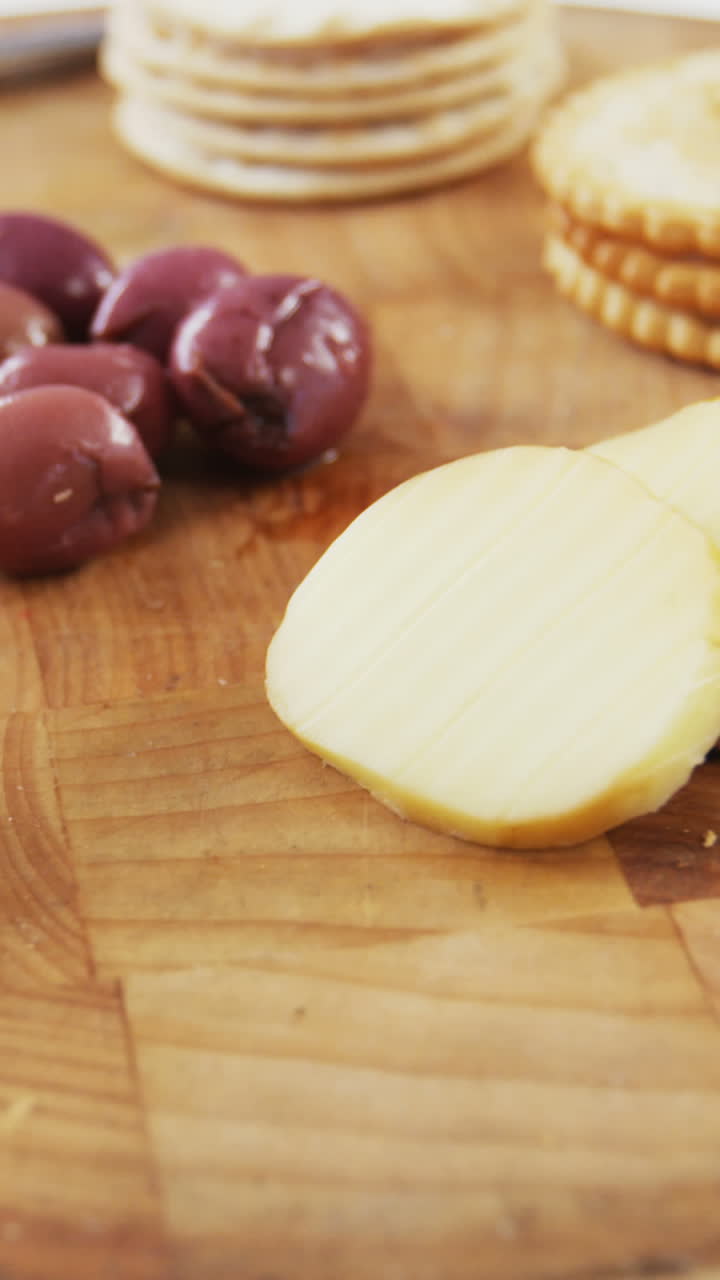 rebanadas de pan, galletas, aceitunas, nuez y cuchillo en tablero de madera