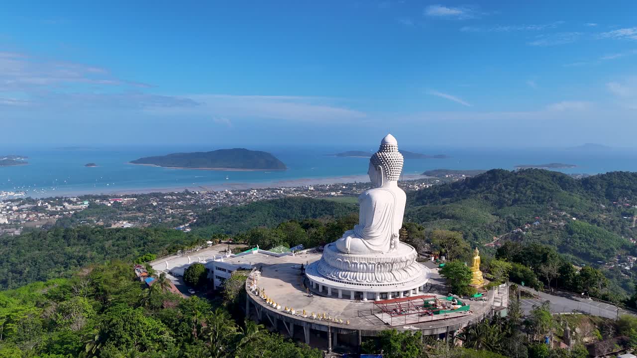 A serene aerial view of the Big Buddha statue in Phuket, Thailand, surrounded by lush greenery and overlooking the ocean