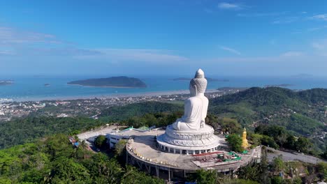 a serene aerial view of the big buddha statue in phuket, thailand, surrounded by lush greenery and overlooking the ocean