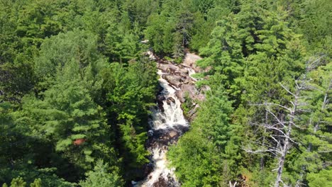 Dron-Descender-Inclinar-Hacia-Arriba-Establecer-Cataratas-Duchesnay,-Bahía-Norte-Ontario-Canadá-Escondido-Detrás-De-árboles,-Cascada-De-Flujo-Fuerte-Cascada-Entera