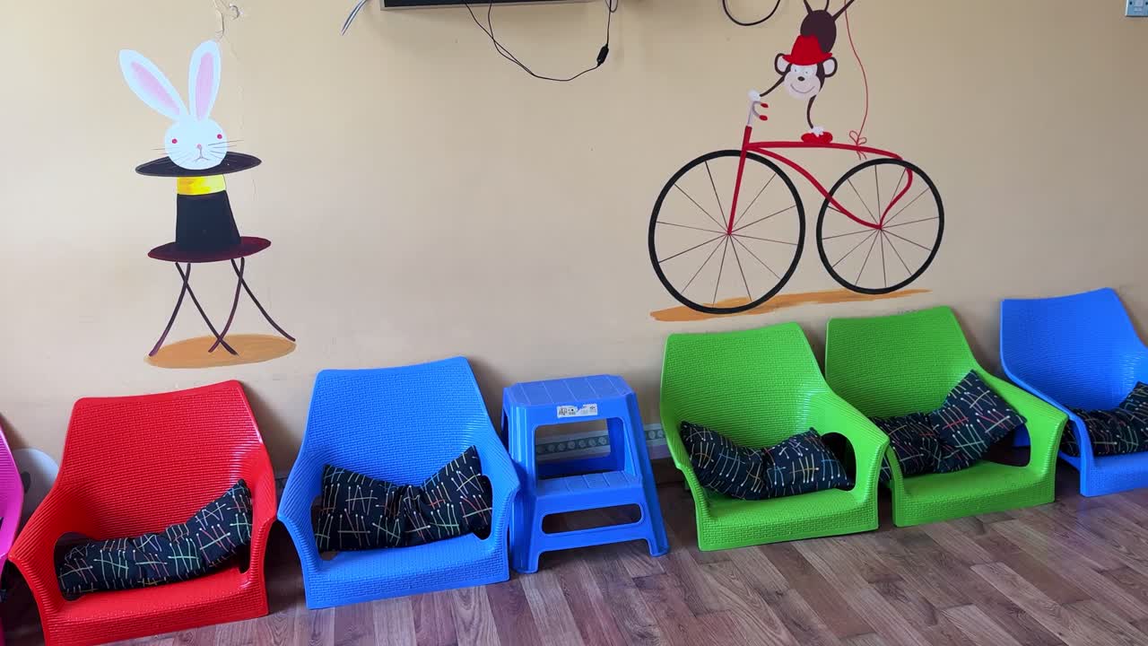 Vibrant plastic chairs with playful wall art in a children's room. Captured in 4K, perfect for education, preschool, furniture, or joyful indoor lifestyle themes.