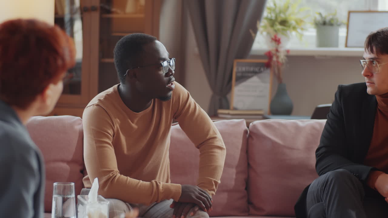 Multiethnic Gay Coupe Speaking with Psychologist on Therapy Session