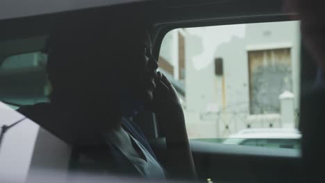 african american woman wearing face mask in car