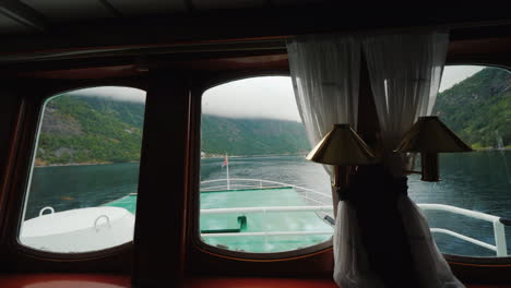 Kreuzfahrt-Auf-Dem-Malerischen-Fjord---Blick-Aus-Dem-Fenster-Des-Schiffes-Eine-Norwegische-Flagge-Ist-Sichtbar-4k-Vi