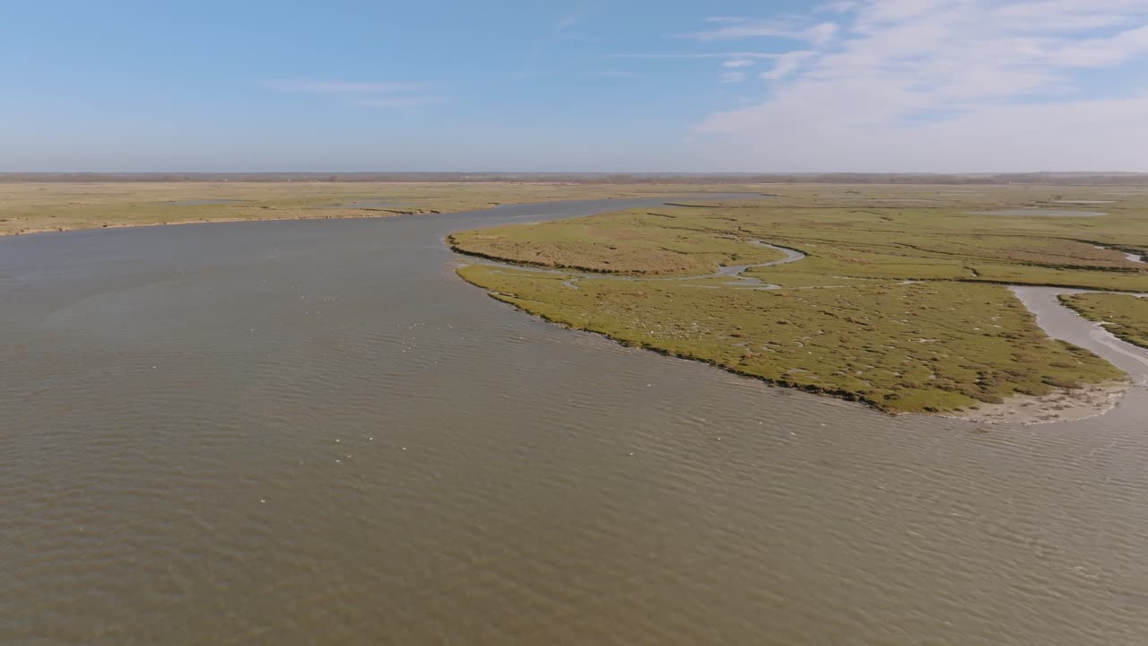 Filmato aereo che traccia la curva di un canale fluviale principale che scorre attraverso le piane di marea dell'estuario della Somme vicino a Saint-Valery