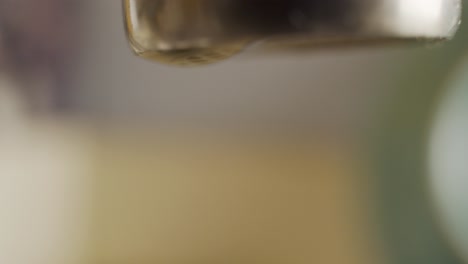 macro shots of a dripping water faucet wasting water