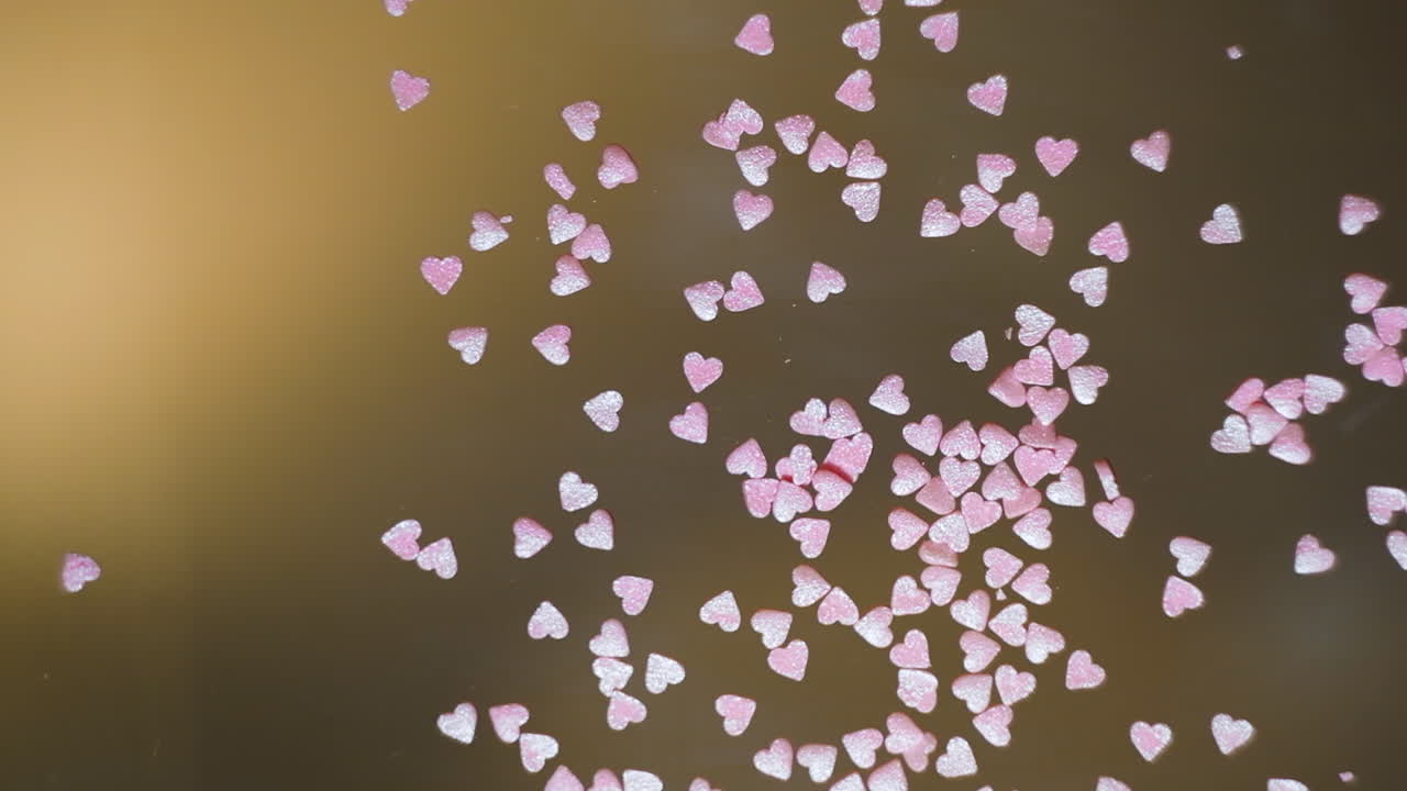 las salpicaduras de corazones rosados esparcidas a mano