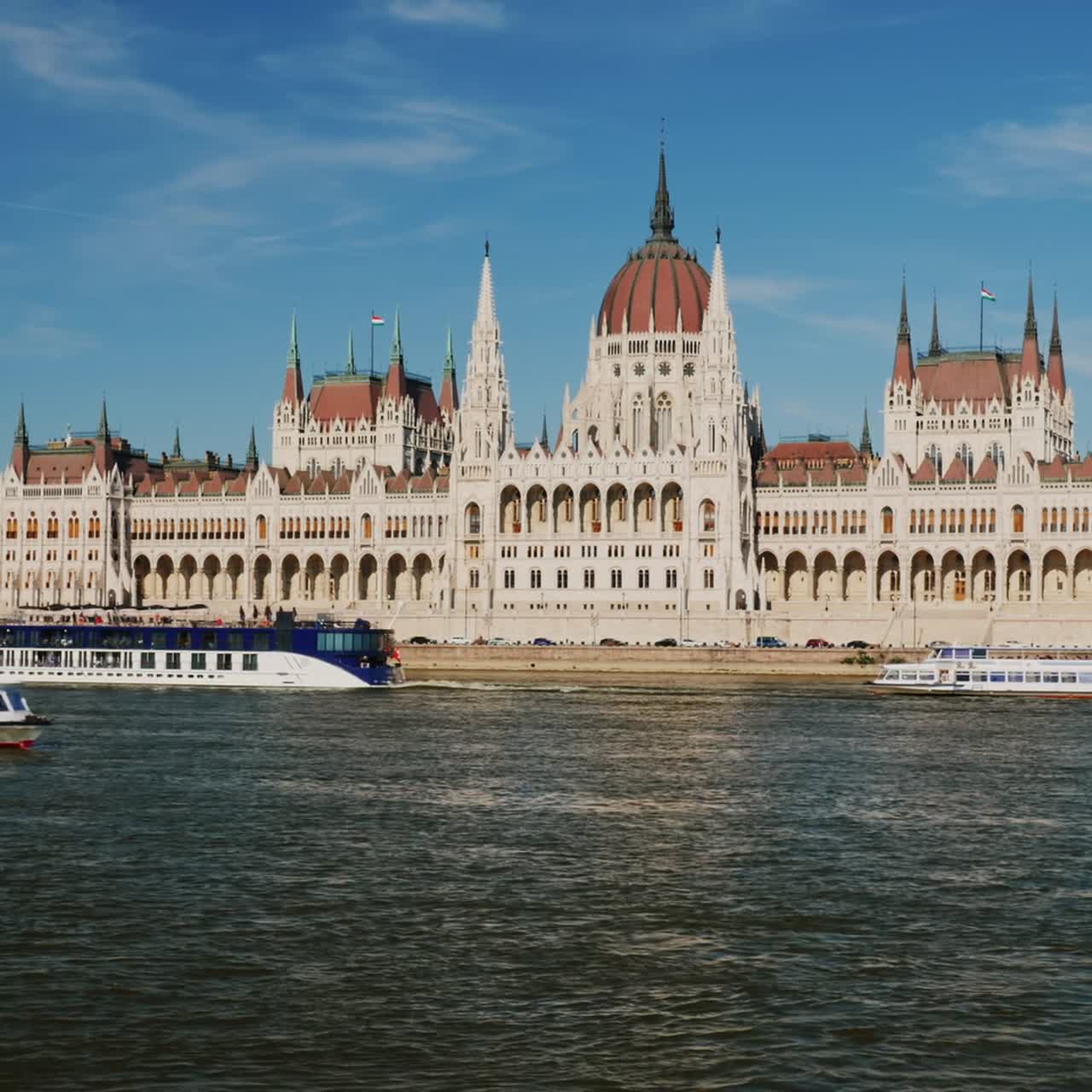 crucero por el río danubio - navegando más allá del edificio del parlamento al atardecer