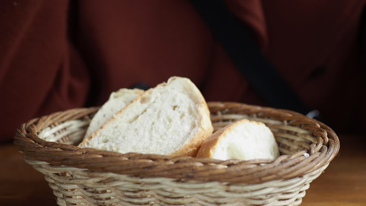 Person eating bread from a basket
