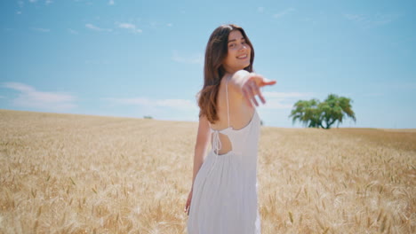 happy woman strolling summer field. carefree girl stretching hand camera walking