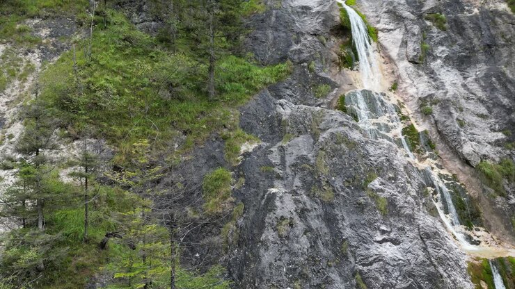 Spettacolare vista aerea con drone in ascesa di una cascata nella gola dell'Almach, Alpi Bavaresi, Germania