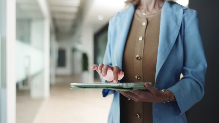 Donna professionista che tocca e scorre su un tablet digitale in ufficio