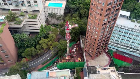 top down view of compact residential construction site with tower crane among high rises