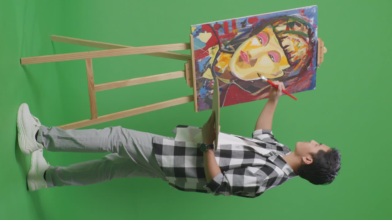 예술가 가 녹색 스크린 에 초상화 를 그리고 있다