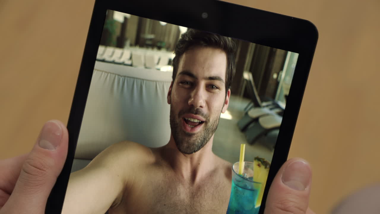 Schermata della videochiamata del tecnico della piscina su tablet in primo piano durante le vacanze. Uomo che tiene in mano un tablet