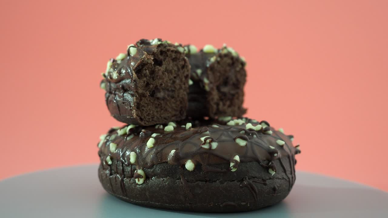 donut de chocolate fresco sobre un fondo rosado. donut de chocolate