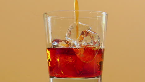 el licor se vierte en un vaso con hielo