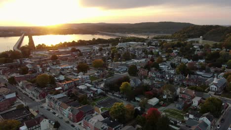 Descending-aerial-on-Columbia,-Pennsylvania,-USA-during-sunset-over-Susquehanna-River