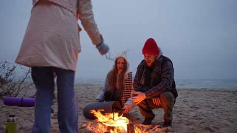 friends enjoying a campfire on the beach at night