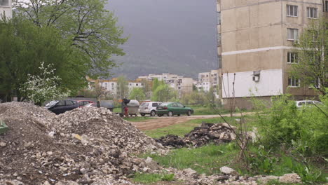 neighborhood of old, brutalist apartment buildings and a pile of dirt in post communist bulgaria in eastern europe