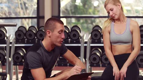 trainer helping client lift weights