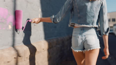 Hermosa-Mujer-Artista-Pintando-Pared-Con-Pintura-Rosa-Caminando-En-La-Calle-De-La-Ciudad-Mujer-Rebelde-Segura-Disfrutando-De-Expresión-Artística-Con-Arte-De-Graffiti-Urbano