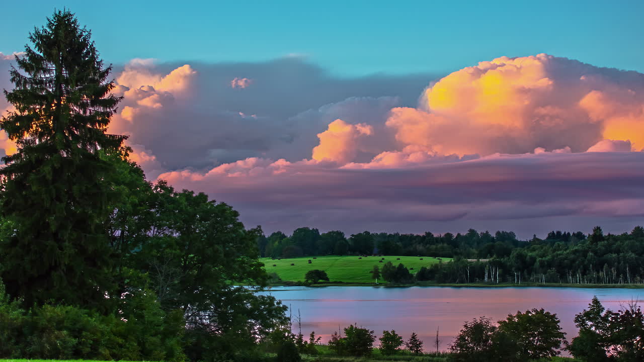 densas nubes iluminadas por la puesta de sol dorada volando sobre el lago natural en el área rural, lapso de tiempo
