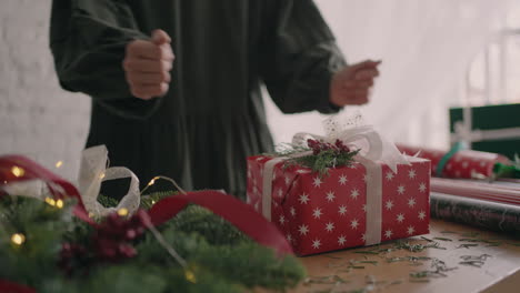 the gift is ready. young beautiful woman gift wrapper wraps up a christmas gift and decorates with decorative eco-friendly decorations. preparation for holiday season.