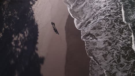drone top view of two women jogging in the beach