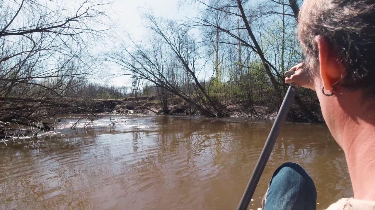 hombre en canoa en un río en un bosque